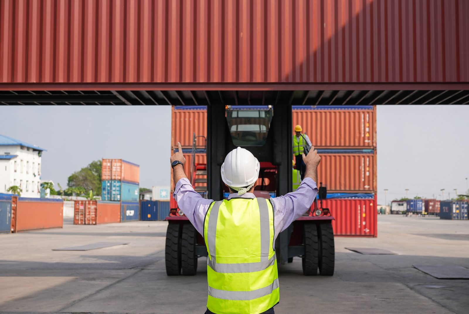 Reach stacker loading a shipping container at a port terminal