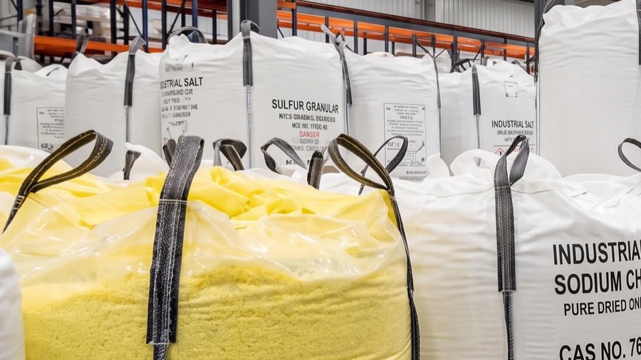 Bulk bag of yellow granular sulphur beside bagged sodium compounds